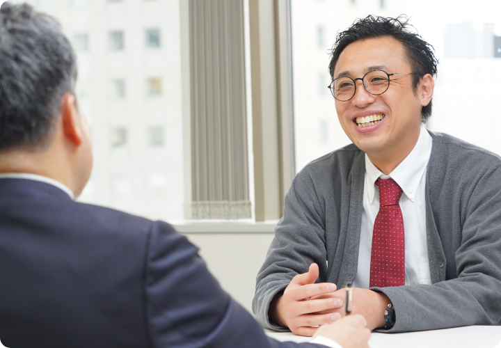 写真：笑顔で上司と会話するS.Nさん