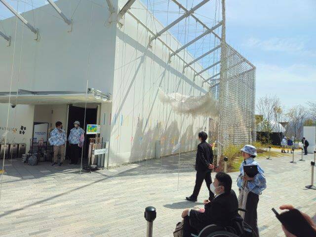 画像:NTTパビリオンの外観をチェック中の車いす社員