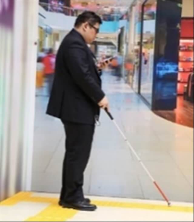 画像:視覚障がい者の社員が屋外でアプリを検証中の様子