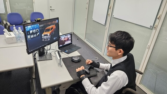画像:肢体不自由者の社員が開発中の機器を使う